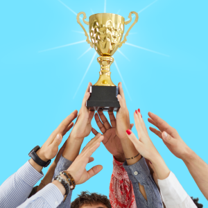 Hands of a diverse group of people reaching for a golden trophy under a bright blue sky.